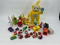 Group shot of all 32 toys including Teletubby doll, figures, vehicles, horse, superheroes