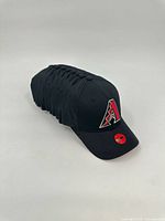 Stack of 11 identical Arizona Diamondbacks caps side view