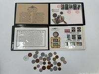 Overall lot: two open coin/stamp covers and spread of loose coins