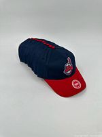 Stack of twelve identical Cleveland Indians youth caps, front view