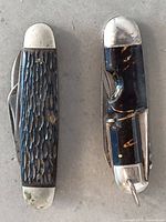 Both pocket knives closed, showing handle materials and bolsters