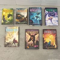 All seven paperback books laid out front covers visible