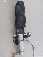 Knife in nylon sheath showing handle, securing straps and accessory pocket