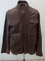 Front view of brown leather jacket on mannequin