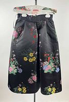 Front view of black floral embroidered Erdem dress hanging on clear hanger with tag visible