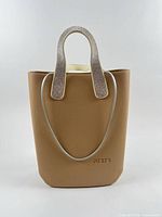 Full view of JU'STO brown bucket handbag showing body shape and embossed logo