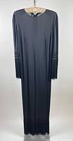 Full view of long black dress on hanger showing length and fringe details