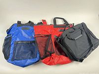 Blue, red and black Eddie Bauer bags front view