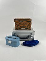 Four jewelry boxes displayed together: wooden box, aluminum case, blue travel case, blue velvet case