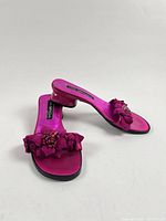Top view of both magenta Via Spiga slide sandals showing floral appliqués and low heel