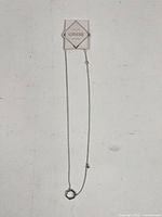 Full view of Birks Bee Chic silver necklace showing chain and hexagonal pendant with Birks tag