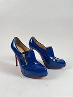 Pair of electric blue patent leather Christian Louboutin heels, showing overall design and condition