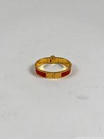 Top view of closed Hermes Clic H bracelet showing full circumference, red enamel, gold-tone metal