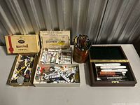 Overview of boxes containing paint tubes, markers container and accessories