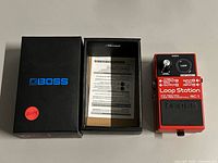Pedal beside original box showing contents