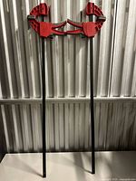Both red Armor Tool Gator bar clamps full length view