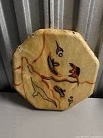 Front of octagonal drum showing painted indigenous motifs