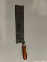 Full view of Kinzo 23 hand saw showing blade, spine, and wooden handle