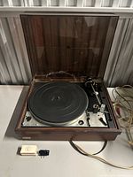 Overall view of Dual 1229Q turntable with dust cover open, accessory pieces visible
