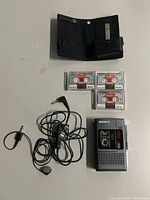 Full lot: recorder, earphone/mic, three tapes, belt-clip case