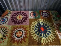 Full view of carpet showing nine square floral motifs and colour palette