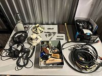 Tabletop view of all items including headphones, resonator cover, slide bars, cables, tin of parts