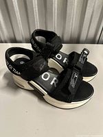 side view of black platform sandals showing straps and white soles