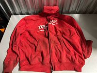 Full view of red Milwaukee heated hoodie laid flat