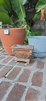 All three planters grouped: terracotta ribbed, blue composite, cast stone urn