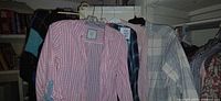 Group of shirts and sweater on hangers showing patterns