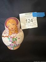 Front view of largest nesting doll with auction tag