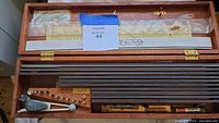 Overview of open wood case showing template rods, scriber, pens and labels