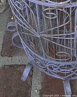 Close view of purple wrought iron bird cage scrollwork and feet