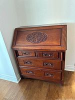 Desk closed showing carved fall front and drawer arrangement