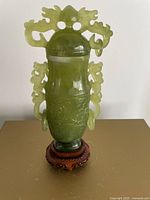 Full view of jade vase on pedestal, showing lid, handles, rings