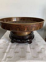 Side view showing red exterior scrollwork bowl on hardwood stand