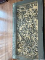 Top view showing carved Chinese battle scene under glass