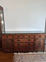 Front view showing drawers, doors, hardware, glass top