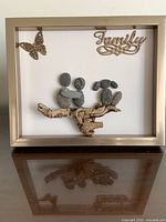 front view of framed stone and wood art showing composition and frame