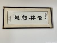 Full view of framed calligraphy artwork showing characters, mat, frame, glass