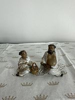 Front view of both glazed ceramic figurines