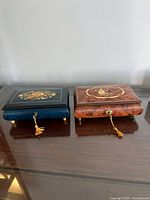 Closed view of both music boxes showing exterior finishes, inlays and brass keys