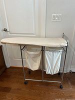 Full view of rolling laundry station, ironing board top, two hampers