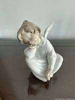 Front view of seated porcelain angel figurine