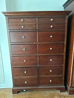 Front view of tall mahogany finish chest showing ten drawers with chrome knobs