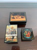 All three lacquer boxes closed showing lid artwork