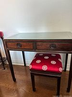 table with glass top and upholstered stool beneath
