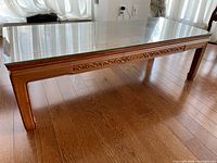 Full view of coffee table showing glass top and wooden frame
