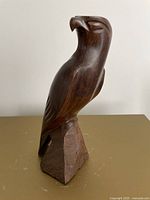front view of carved wood bird of prey on base