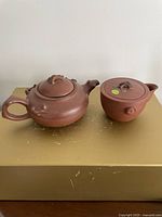 Both Yixing teapots side by side on surface